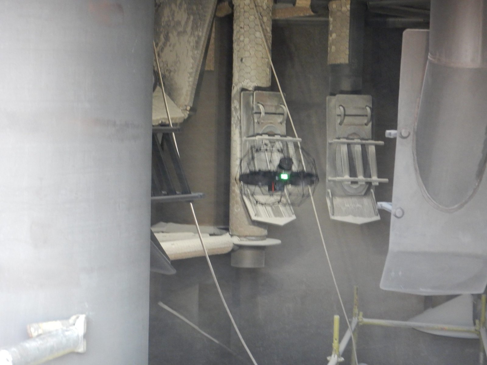 Caged drone flying inside a dusty vessel